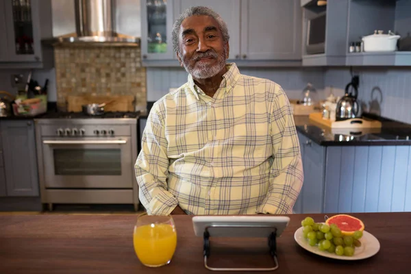 Улыбающийся пожилой человек на кухне — стоковое фото