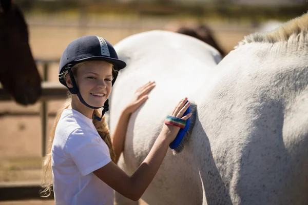 Fille toilettant le cheval dans le ranch — Photo