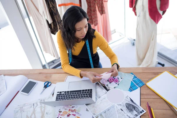 Diseñadora femenina trabajando en piezas de ropa — Foto de Stock