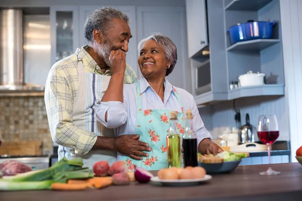 Casal idoso afetuoso preparando alimentos — Fotografia de Stock