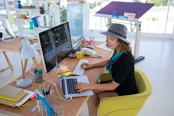 Ejecutivo femenino usando laptop y computadora —  Fotos de Stock