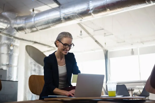 Giovane donna utilizzando il computer portatile in ufficio — Foto Stock