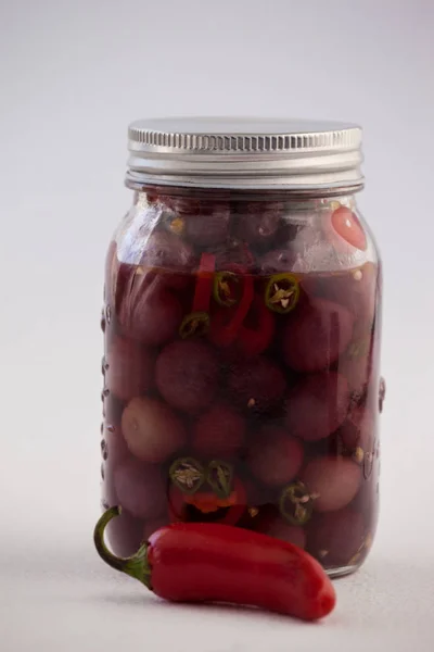 Красные оливки с халапеньо в контейнере — стоковое фото