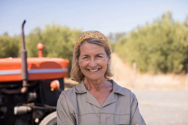 Femme debout contre tracteur dans l'exploitation oléicole — Photo