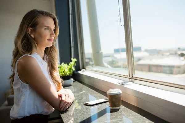 Business woman looking through window — стоковое фото