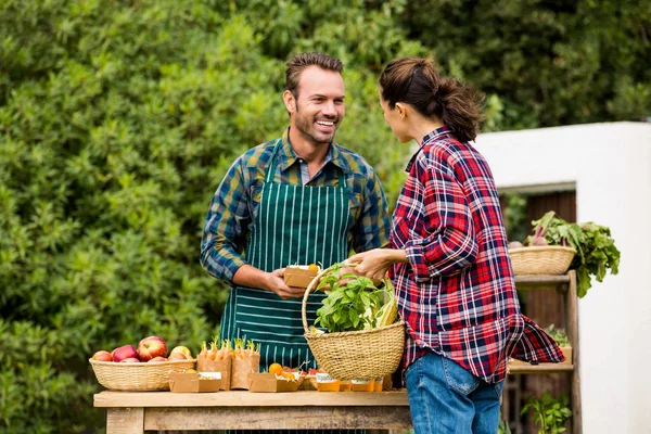 Mulher comprando vegetais orgânicos do homem — Fotografia de Stock