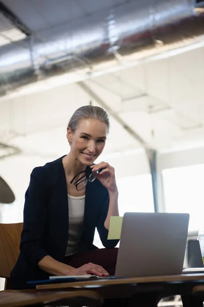 Young woman using laptop in office — Stock Photo, Image