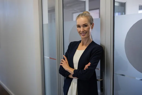 Geschäftsfrau mit verschränkten Armen vor der Tür — Stockfoto