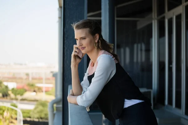 Woman talking on mobile phone in balcony — Stock Photo, Image