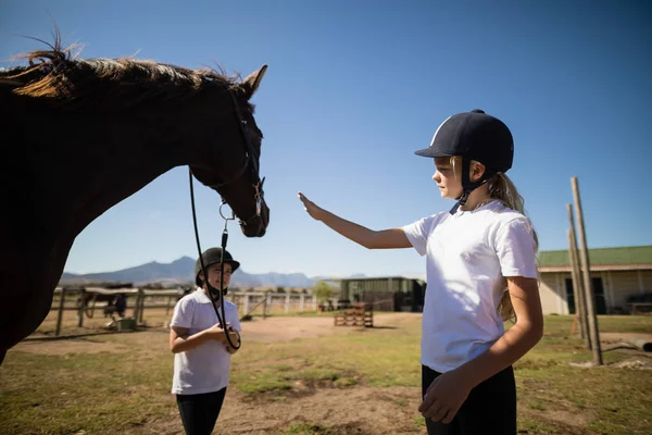 Meninas de pé com um cavalo na fazenda — Fotografia de Stock