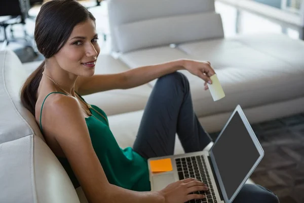 Vrouw met zelfklevende opmerking met behulp van laptop op kantoor — Stockfoto