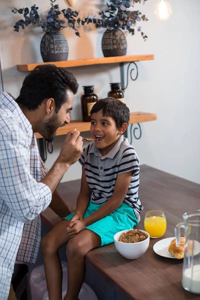 Pai alimentando café da manhã de cereais para filho — Fotografia de Stock