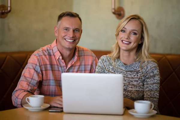 Casal usando laptop enquanto toma café — Fotografia de Stock