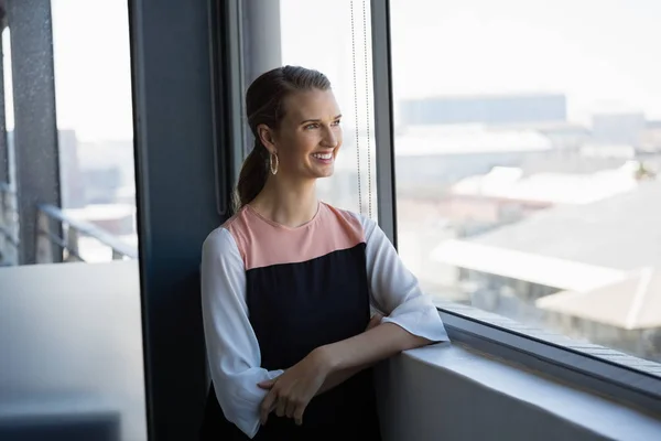 Женщина смотрит через окно в офис — стоковое фото