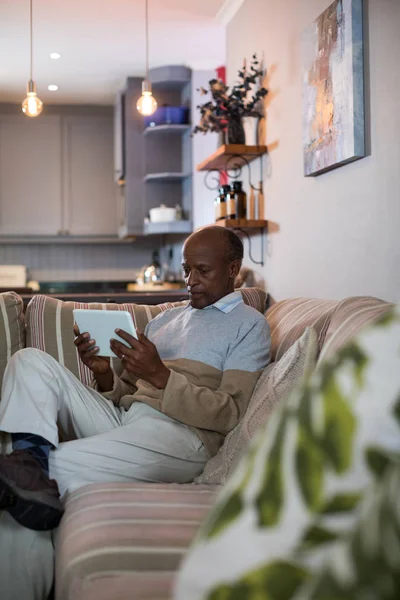 Ανώτερος άντρας που χρησιμοποιεί tablet στο σπίτι — Φωτογραφία Αρχείου