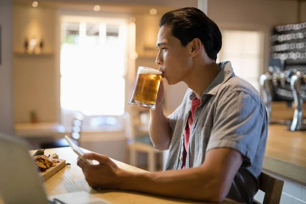 Mann benutzt digitales Tablet beim Bier — Stockfoto