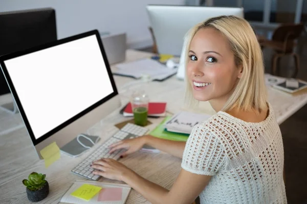 Portrait of woman using computer while working at office — Stock Photo, Image