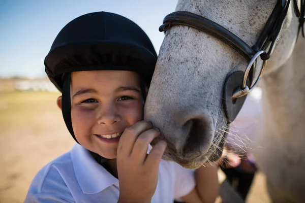 Cavaleiro menino tocando o cavalo branco — Fotografia de Stock