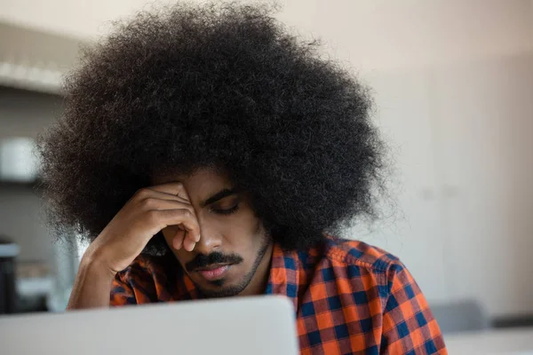 Trött man med lockigt hår på kontor — Stockfoto