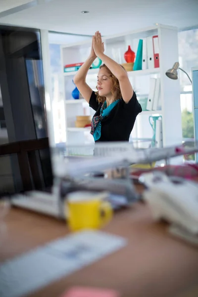 Eksekutif wanita melakukan yoga di kantor — Stok Foto