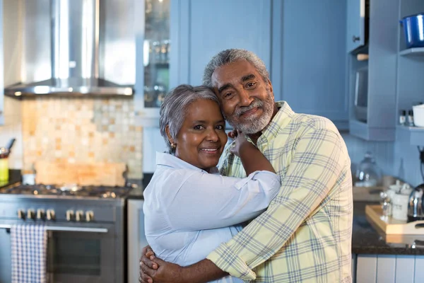 Pareja abrazando mientras de pie en la cocina —  Fotos de Stock