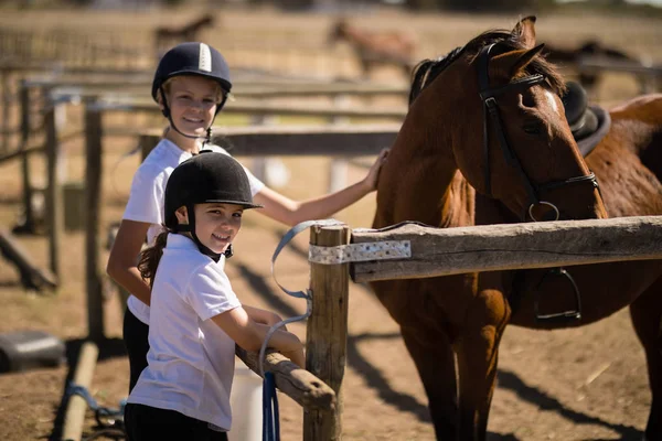 Meninas de pé perto do cavalo marrom — Fotografia de Stock