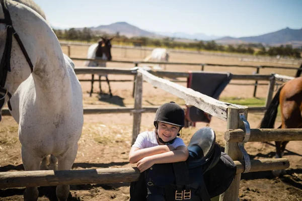 Menina inclinada sobre a cerca no rancho — Fotografia de Stock