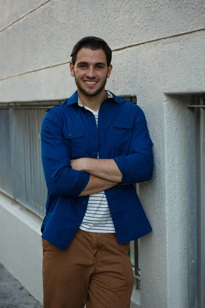 Homme avec les bras croisés appuyé sur le mur — Photo