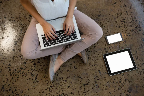 Mulher usando laptop no chão no escritório — Fotografia de Stock