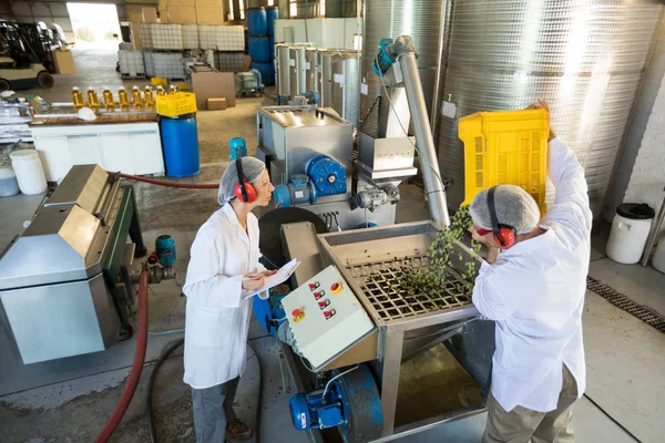 Trabalhadores trabalhando juntos perto da linha de produção — Fotografia de Stock