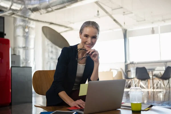 Young woman using laptop in office — Stock Photo, Image