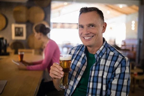 Homme prenant un verre de bière au comptoir du bar — Photo