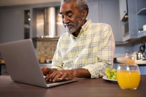 Gülümseyen adam dizüstü bilgisayar kullanıyor — Stok fotoğraf