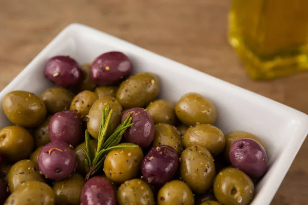 Оливки с розмарином в миске — стоковое фото