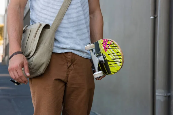 Midsection av man håller skateboard — Stockfoto