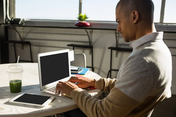 Concentrated man using laptop at office — Stock Photo, Image