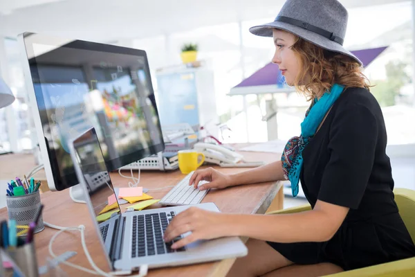 Executivo feminino usando laptop na mesa — Fotografia de Stock