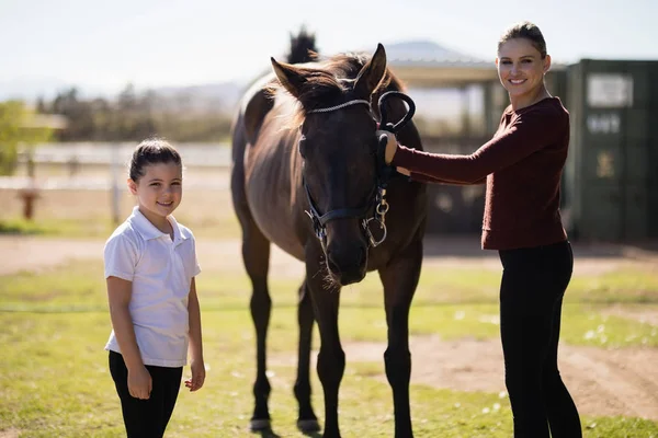 Mother and daughter wit brown horse — Stock Photo, Image