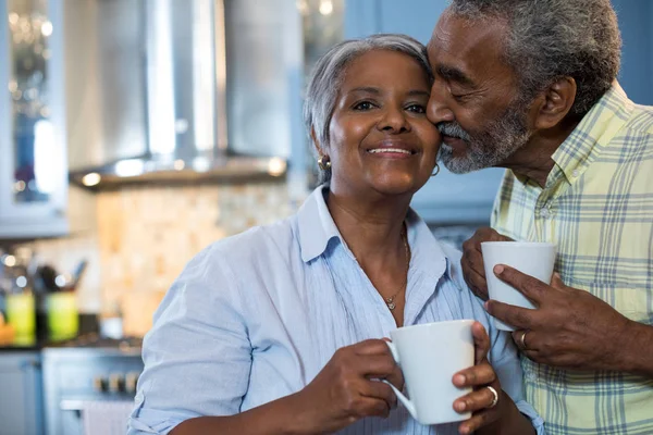 Affectionate man with woman in kitchen — Stock Photo, Image