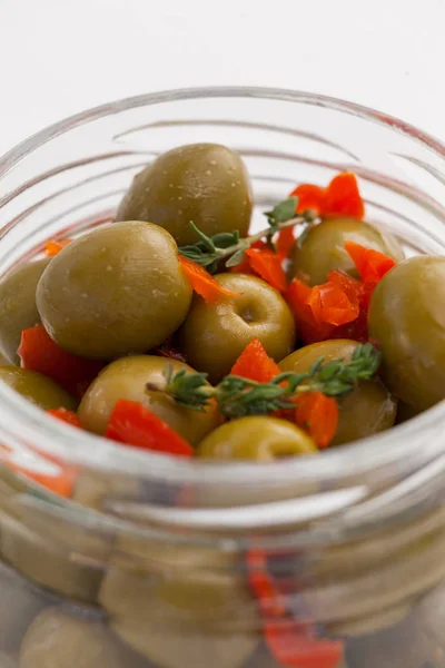 Gröna oliver med örter i burk — Stockfoto