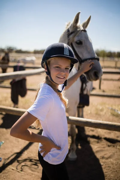 Дівчина торкається коня на ранчо — стокове фото