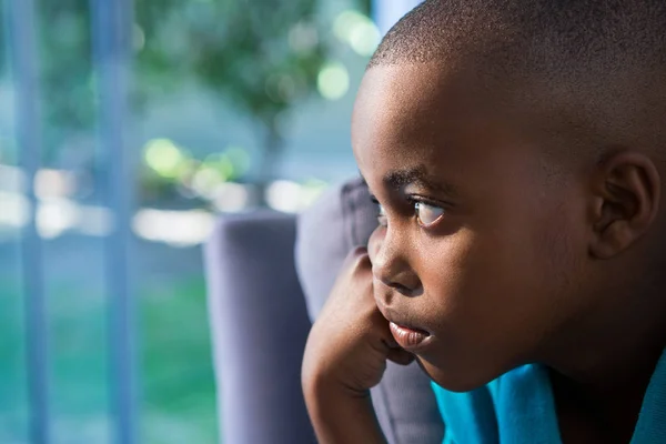 Przemyślane chłopiec ogląda okna — Zdjęcie stockowe