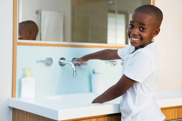 Uśmiechnięty chłopiec mycie rąk w zlew — Zdjęcie stockowe