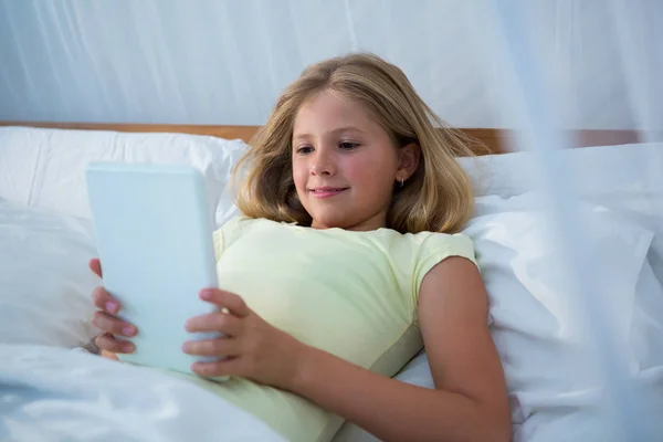 Девушка с планшетом на кровати — стоковое фото