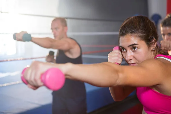 Woman punching with dumbbell — Stock Photo, Image