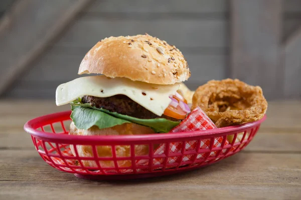 Hamburgare och lök ringar i korg — Stockfoto