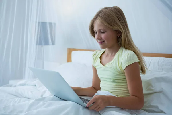 Dívka pomocí přenosného počítače na posteli — Stock fotografie