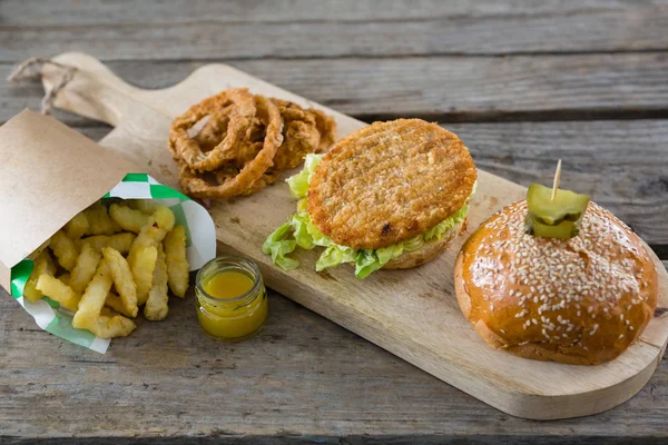 Hambúrguer com anéis de cebola e batatas fritas — Fotografia de Stock