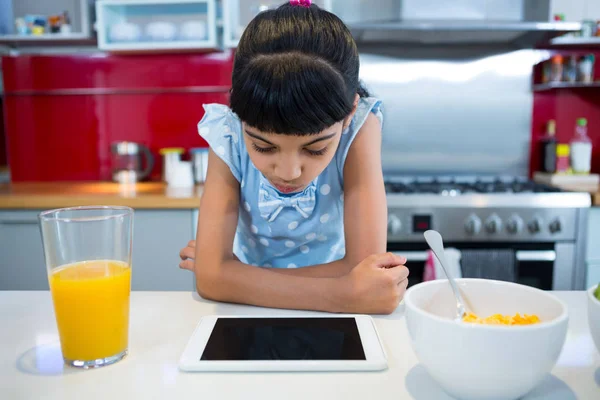 Девушка с помощью планшетного компьютера на кухне — стоковое фото