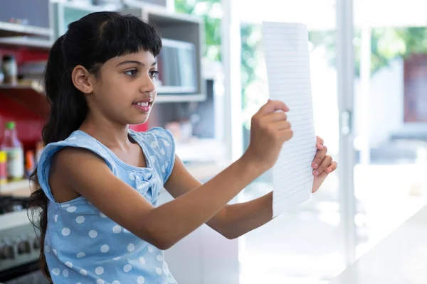 Chica leyendo papel en la cocina —  Fotos de Stock